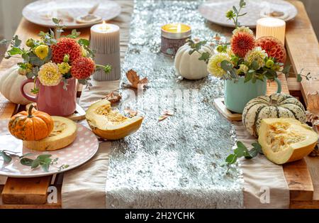 Festliche Tischkulisse mit Kürbissen und Chrysantheme-Blumen. Stockfoto