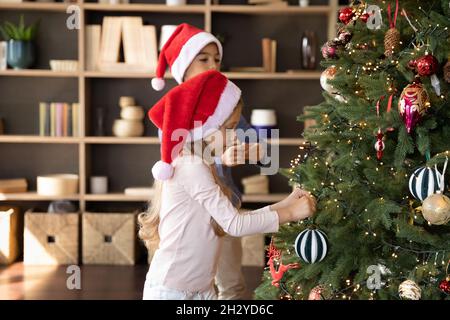 Glücklich liebenswert kleine Kinder Dekoration festlichen Baum. Stockfoto