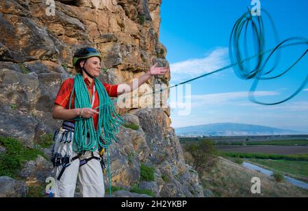 Weibliche Klettererin, die das Seil umwickelt Stockfoto