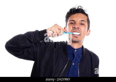 Mann, der sich den Mund putzt, isoliert auf weißem Hintergrund. Junger lateiner, der sich vor der Kamera den Mund putzt. Stockfoto