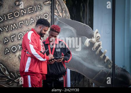 Bild von zwei afroamerikanischen Touristen in belgrad, serbien, in Sportanzug, lächelnd und mit ihrem Smartphone-Telefon . Stockfoto