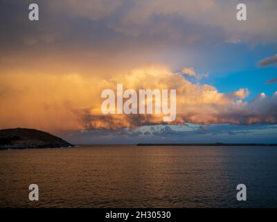 Blick nach Osten auf Muttonbird Island und die Südmauer vom Jetty, Sonnenuntergang mit rosafarbenem Orange in Wolken und Meerwasser, stimmungsvoller Himmel Stockfoto