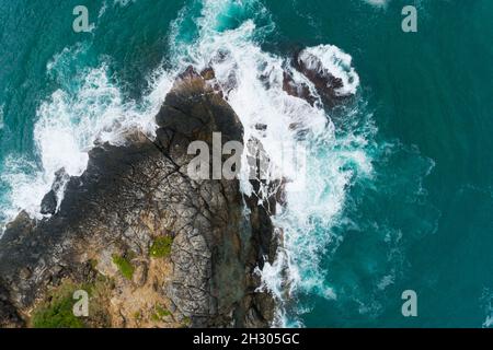 Luftaufnahme der Wellen am Meer Weiße schäumende Wellen auf den Felsen am Meer Draufsicht fantastische Rocky Coast erstaunliche Natur Hintergrund. Stockfoto