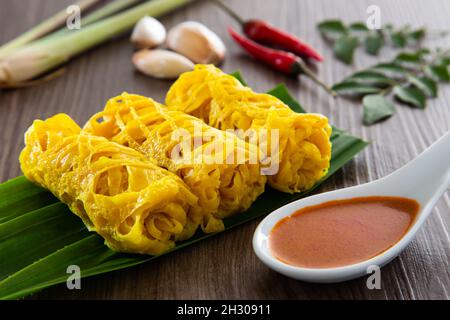 Roti Jala oder Spitzenpfannkuchen ist malaysisches traditionelles Essen, ein beliebter malaiischer Snack, der mit einem Angebot an Gerichten aus dem Gebiet des „Currys“ serviert wird Stockfoto