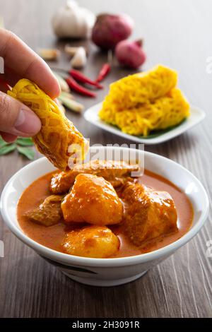 Roti Jala oder Spitzenpfannkuchen ist malaysisches traditionelles Essen, ein beliebter malaiischer Snack, der mit einem Angebot an Gerichten aus dem Gebiet des „Currys“ serviert wird Stockfoto