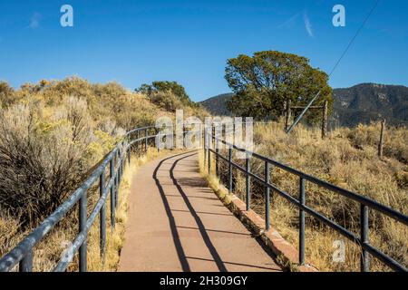 Ein Gehweg oder Bürgersteig führt durch die Wüste in der Nähe des „Kreuzes der Märtyrer“ in Santa Fe, NM Stockfoto