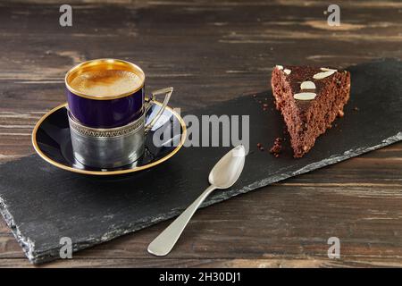 Herbstlicher Brownie-Kuchen mit Walnüssen und Schokolade. Tasse Kaffee auf dem Hintergrund. Französische Gourmetküche Stockfoto
