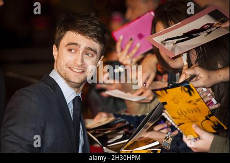 Daniel Radcliffe signiert Autogramme für Fans, während er bei der Premiere von Kill Your Darlings im Rahmen des 57. BFI Film Festivals auf dem Odeon Leicester Square in London ankommt Stockfoto