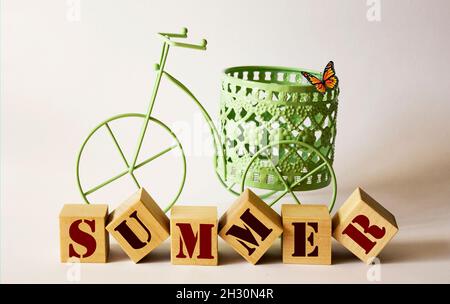 Wort Sommer auf Holzblöcken und Fahrrad auf weißem Hintergrund Stockfoto