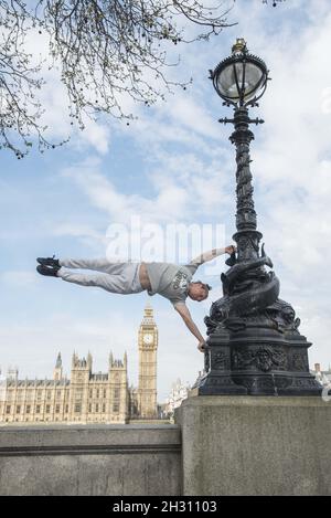 Tim Shieff führt Parkour im Mowgli-Stil während einer Fotowand vor dem Parlament auf. Parkour Pro Tim wird auf der Southbank Meisterkurse durchführen, die von Mowgli inspiriert sind, um die Einführung von The Jungle Book, Jubillee Gardens, Southbank - London zu feiern Stockfoto