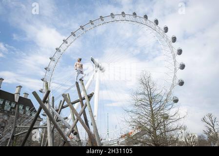 Tim Shieff führt Parkour im Mowgli-Stil während einer Fotowand vor dem Parlament auf. Parkour Pro Tim wird auf der Southbank Meisterkurse durchführen, die von Mowgli inspiriert sind, um die Einführung von The Jungle Book, Jubillee Gardens, Southbank - London zu feiern Stockfoto