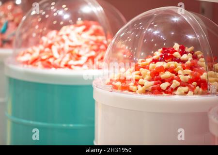 Gelee-Bonbons in Behältern in einem Geschäft. Große Auswahl an Süßigkeiten in verschiedenen Farben. Verkauf von Süßigkeiten. Stockfoto