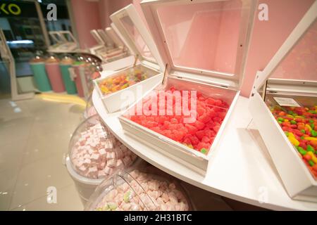 Gelee-Bonbons in Behältern in einem Geschäft. Große Auswahl an Süßigkeiten in verschiedenen Farben. Verkauf von Süßigkeiten. Stockfoto