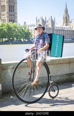 A man liefert während der Coronavirus-Pandemie, Westminster, London, Lebensmittel für Deliveroo auf einem Penny Farthing-Fahrrad. Bilddatum: Montag, 25. Mai 2020. Bildnachweis sollte lauten: David Jensen/EMPICS Entertainment Stockfoto