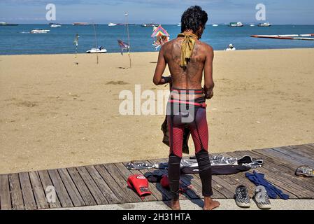 Ungewöhnlicher Kleidstil einschließlich weiblicher Strumpfgürtel, der von einem ausstrahlten Mann am Pattaya Beach Thailand Southeast Asia getragen wird Stockfoto
