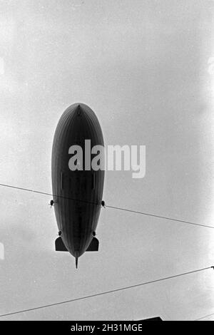 Zeppelin LZ 129 Hindenburg bei der olympiafahrt über Berlin, Deutschland 1930er Jahre. Zeppeilin Hindenburg LZ 129 auf seiner olympischen Fahrt über Berlin, Deutschland 1930. Stockfoto