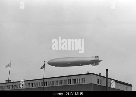 Zeppelin LZ 129 Hindenburg bei der olympiafahrt über Berlin, Deutschland 1930er Jahre. Zeppeilin Hindenburg LZ 129 auf seiner olympischen Fahrt über Berlin, Deutschland 1930. Stockfoto