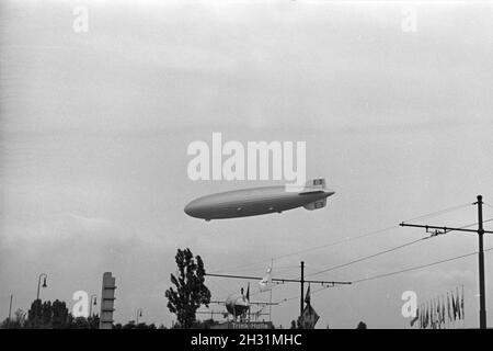 Zeppelin LZ 129 Hindenburg bei der olympiafahrt über Berlin, Deutschland 1930er Jahre. Zeppeilin Hindenburg LZ 129 auf seiner olympischen Fahrt über Berlin, Deutschland 1930. Stockfoto