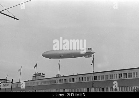 Zeppelin LZ 129 Hindenburg bei der olympiafahrt über Berlin, Deutschland 1930er Jahre. Zeppeilin Hindenburg LZ 129 auf seiner olympischen Fahrt über Berlin, Deutschland 1930. Stockfoto