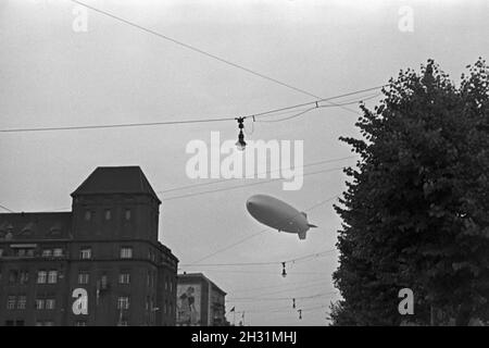 Zeppelin LZ 129 Hindenburg bei der olympiafahrt über Berlin, Deutschland 1930er Jahre. Zeppeilin Hindenburg LZ 129 auf seiner olympischen Fahrt über Berlin, Deutschland 1930. Stockfoto