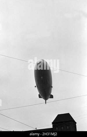 Zeppelin LZ 129 Hindenburg bei der olympiafahrt über Berlin, Deutschland 1930er Jahre. Zeppeilin Hindenburg LZ 129 auf seiner olympischen Fahrt über Berlin, Deutschland 1930. Stockfoto