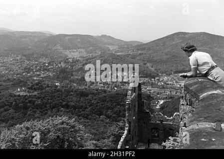 Eine junge Frau genießt den Ausblick von der Schlossruine Hohenbaden im Nordschwarzwald in die Stadt Baden-Baden, Deutschland 1930er Jahre. Eine junge Frau genießt den Blick auf Baden-Baden von der Ruine Hohenbaden Schloss, Deutschland 1930. Stockfoto