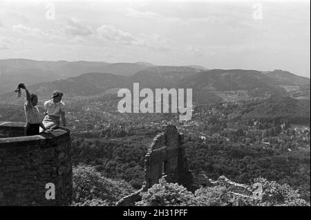 Zwei junge Frauen genießen den Ausblick von der Schlossruine Hohenbaden im Nordschwarzwald in die Stadt Baden-Baden, Deutschland 1930er Jahre. Zwei junge Frauen genießen Sie den Blick auf Baden-Baden von der Ruine Hohenbaden Schloss, Deutschland 1930. Stockfoto