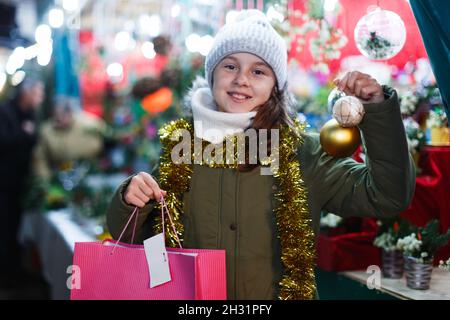 Junges Mädchen demonstraiting Dekorationen für Weihnachtsbaum Stockfoto