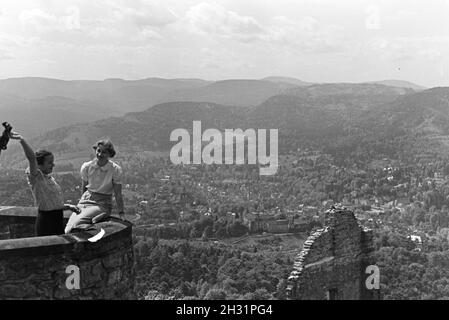 Zwei junge Frauen genießen den Ausblick von der Schlossruine Hohenbaden im Nordschwarzwald in die Stadt Baden-Baden, Deutschland 1930er Jahre. Zwei junge Frauen genießen Sie den Blick auf Baden-Baden von der Ruine Hohenbaden Schloss, Deutschland 1930. Stockfoto