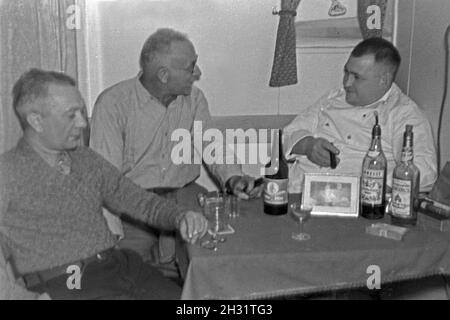 Drei Männer der Besatzung des Walfangfabrikschiffs "Jan Wellem" bei Löwen mit Zgarren erPause und Cognac, 1930er Jahre. Drei Besatzungsmitglieder des facotry Schiff "Jan Wellem" eine Pause mit Zigarren und Brandy, 1930er Jahre. Stockfoto