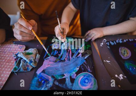 High-Angle-Ansicht von nicht erkennbarem Vater mit kleinen Kind Gemälde Bilder drinnen zu Hause. Stockfoto