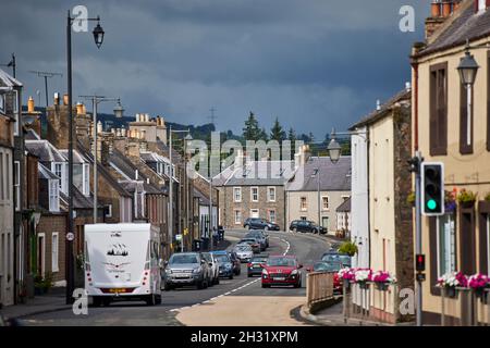 Lauder, in den schottischen Boarders Scotland, dachte A68 High Street, dass das Dorf auf eine Geschwindigkeitsbegrenzung von 20 km/h eingestellt war, das rote Auto geht langsam, Stockfoto