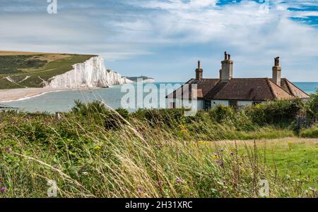 Englische Hütten. Die zerklüftete Küste von East Sussex mit Blick auf Cuckmere Haven und die weißen Kreidefelsen der Seven Sisters in den Ärmelkanal. Stockfoto
