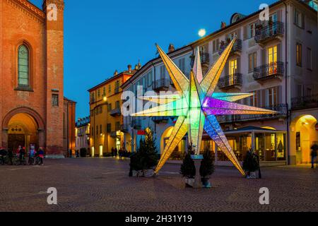 Beleuchteter bunter Weihnachtsstern auf dem Altstadtplatz in Alba, Piemont, Norditalien. Stockfoto