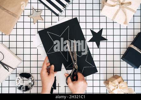 Kreative Geschenkideen. Personalisierte Geschenke. Moderne schwarz-weiße Flachlage mit Geschenkverpackung Verfahren. Scheren, verpackt Handwerk Boxen und Stockfoto