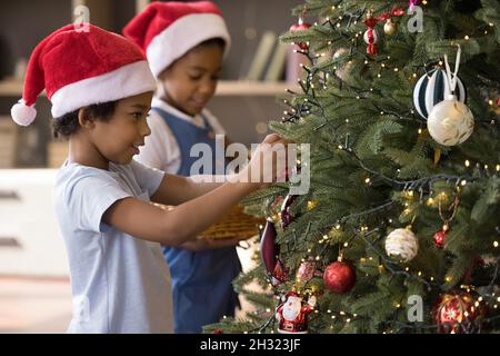 Glückliche gemischte Rennen Kinder Dekoration Weihnachtsbaum. Stockfoto