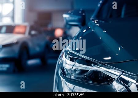 Selektiver Fokus graues Auto in Luxus-Showroom geparkt. Autohaus. Neues Auto in modernem Showroom geparkt. Auto zu verkaufen und mieten Business-Konzept. Stockfoto