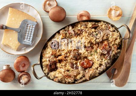 Risotto ai funghi, Pilzreis, mit Zutaten, oben flach lag auf einem hölzernen Hintergrund geschossen Stockfoto