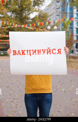 Eine Frau hält ein Plakat mit einer Inschrift, übersetzt aus dem Ukrainischen geimpft Stockfoto