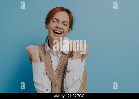 Junge glücklich zufrieden junge rothaarige Frau mit geschlossenen Augen feiern Erfolg Stockfoto