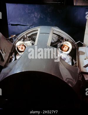 (März 1964) --- die Astronauten Virgil I. (GUS) Grissom (rechts) und John W. Young, die erste bemannte Gemini-Mission (GT-3), werden in einem Gemini-Missionssimulator bei McDonnell Aircraft Corp., St. Louis, MO, gezeigt. Der Simulator wird Zwillinge-Astronauten und Bodencrews während des intensiven Trainings vor dem eigentlichen Start mit einer realistischen Missionssimulation versorgen. Stockfoto