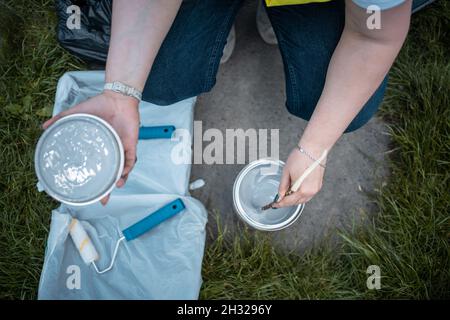 Arbeiter, der Farbe oder Farbstoff im Eimer mischt, bevor er Wände malt Stockfoto