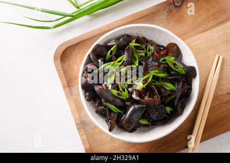 Salat aus chinesischen eingelegten schwarzen Maultierpilzen in einer Schüssel auf weißem Hintergrund. Blick von oben. Stockfoto