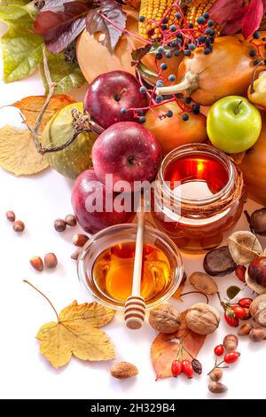 Honig, Äpfel und Herbstfrüchte auf weißem Hintergrund Stockfoto