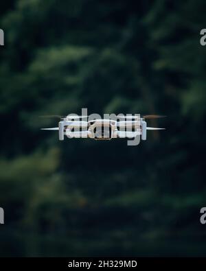 ZENICA, BOSNIEN UND HERZEGOWINA - 29. Jul 2021: Eine vertikale Aufnahme einer DJI MINI 2 Drohne, die tagsüber im Wald fliegt Stockfoto