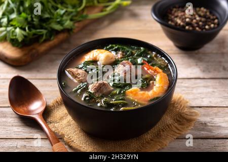 Rindfleisch, Okra-Eintopf und Spinatsuppe in einer Schüssel auf einem Holztisch Stockfoto