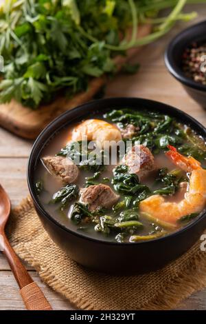 Rindfleisch, Okra-Eintopf und Spinatsuppe in einer Schüssel auf einem Holztisch Stockfoto