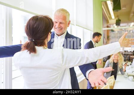 Ältere Geschäftsleute und Kollegen freuen sich, wenn sie begrüßt werden oder einen Erfolg feiern Stockfoto