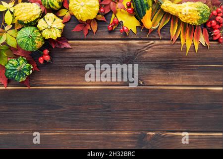 Herbsthintergrund mit Kürbissen, bunten Blättern auf einem dunklen Holztisch. Happy Thanksgiving Konzept. Draufsicht, Platz für Text kopieren Stockfoto