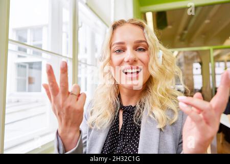 Junge Geschäftsfrau mit Kopfhörern, die bei Videokonferenzen spricht oder Musik hört Stockfoto